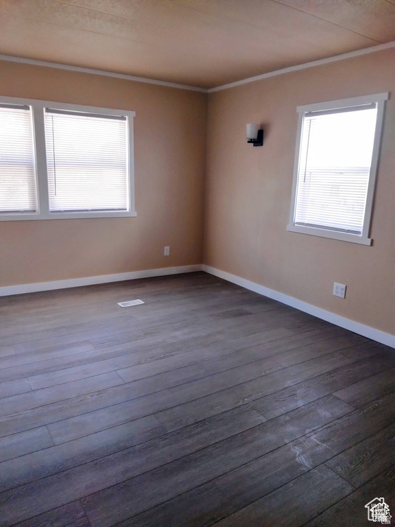 Unfurnished room featuring wood finished floors and crown molding