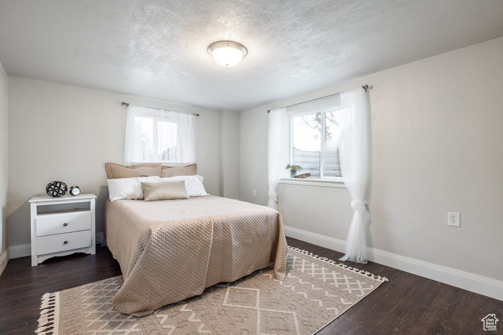 Bedroom with wood finished floors and a textured ceiling