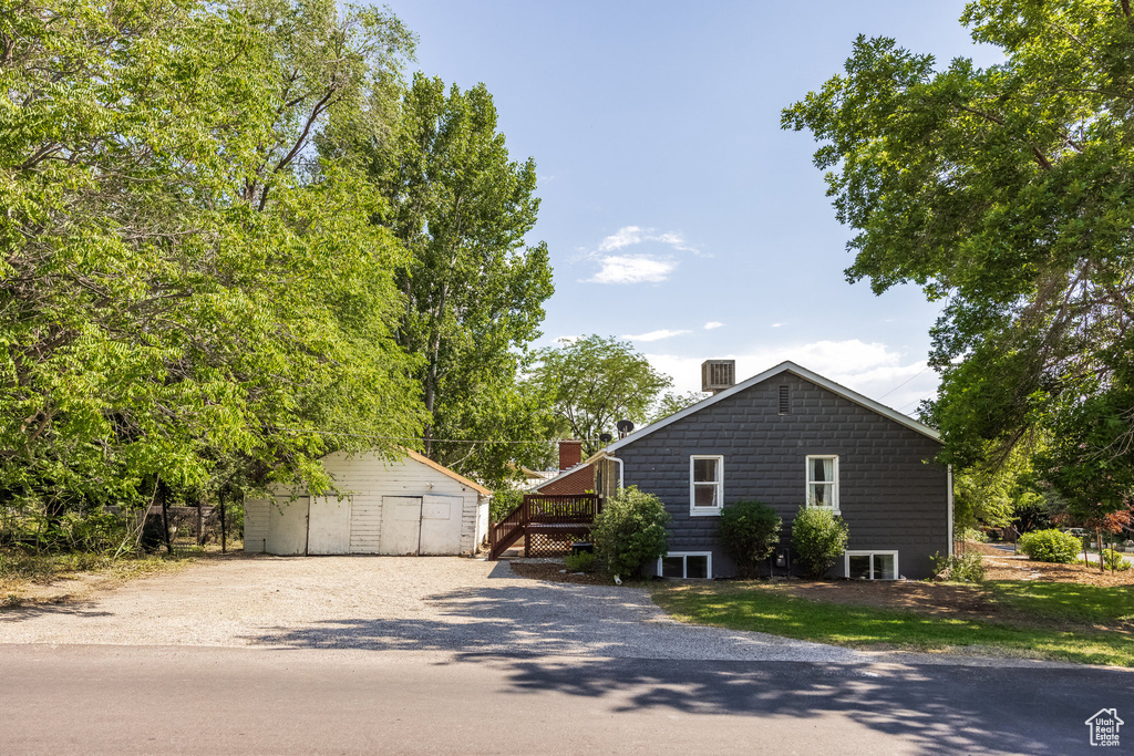 View of home's exterior with an outdoor structure, a detached garage, and a chimney