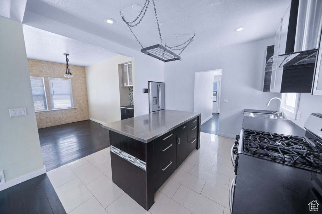 Kitchen featuring stainless steel countertops, appliances with stainless steel finishes, dark cabinetry, healthy amount of natural light, and recessed lighting