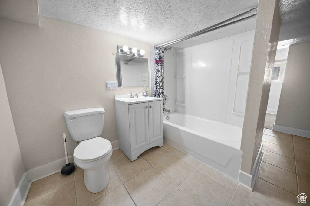 Full bath with vanity, a textured ceiling, tile patterned floors, and shower / bathtub combination with curtain