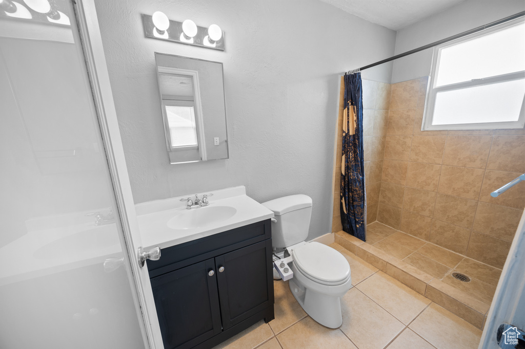 Bathroom with a shower stall, vanity, and tile patterned flooring