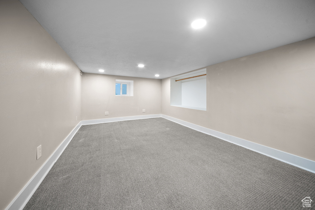 Below grade area featuring recessed lighting and dark colored carpet