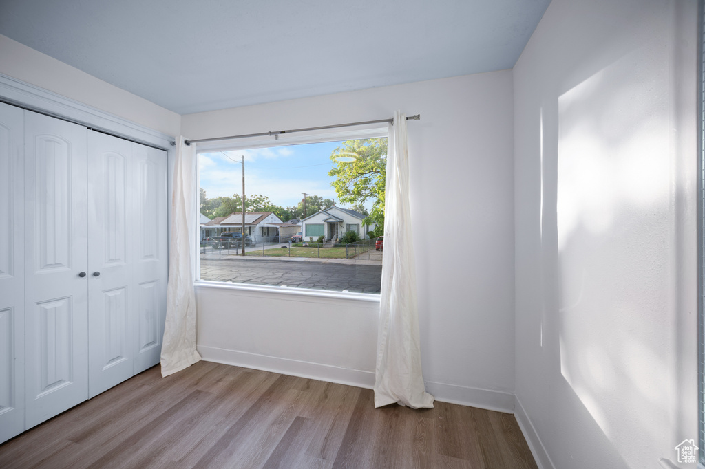 Unfurnished bedroom with wood finished floors and a closet