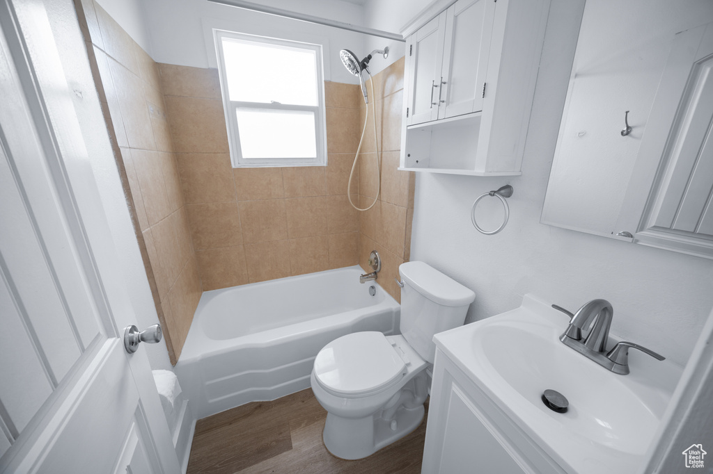 Full bath featuring vanity, bathtub / shower combination, and wood finished floors