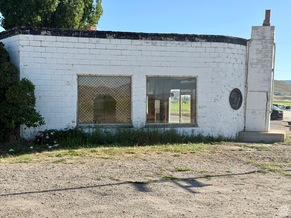 View of property exterior with concrete block siding and a chimney