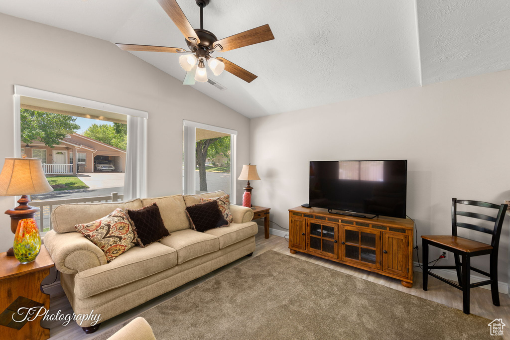 Living room featuring wood finished floors, vaulted ceiling, and ceiling fan