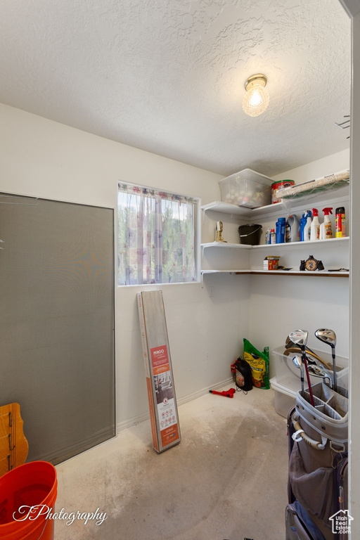 Carpeted bedroom with a textured ceiling and baseboards