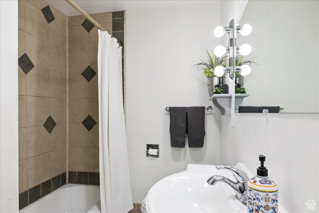 Bathroom featuring a sink and shower / tub combo