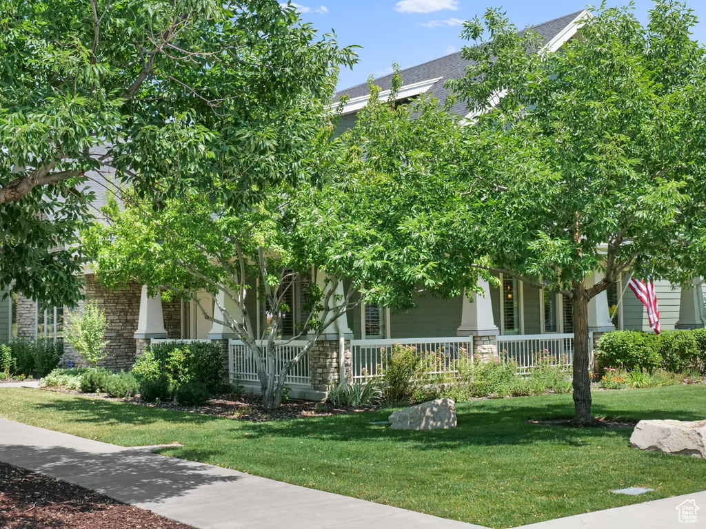 Obstructed view of property featuring a porch and a front yard