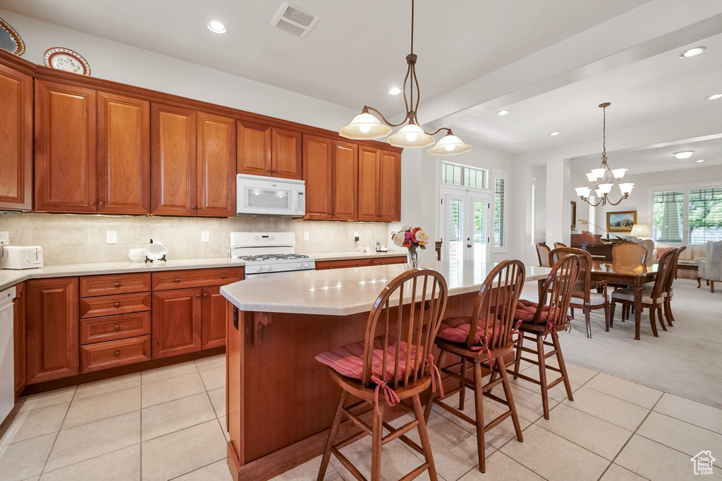 Kitchen featuring white appliances, light tile patterned floors, light countertops, french doors, and recessed lighting