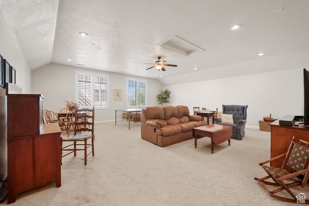 Living room with vaulted ceiling, light colored carpet, recessed lighting, and attic access