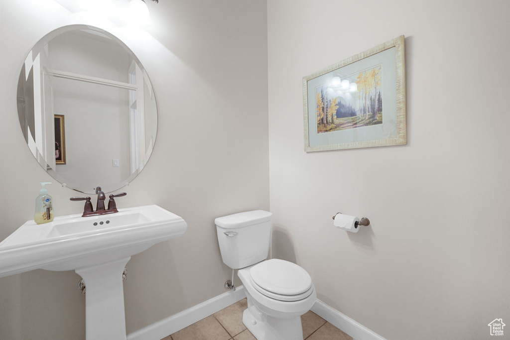 Half bath with toilet and tile patterned flooring