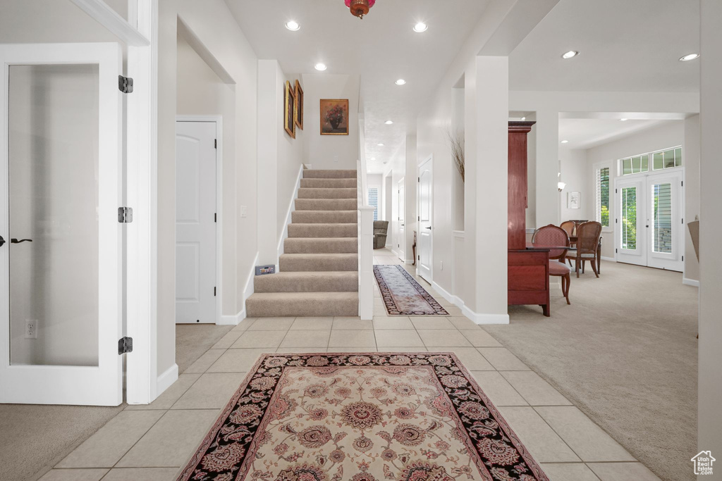 Staircase featuring carpet floors, tile patterned flooring, recessed lighting, and french doors