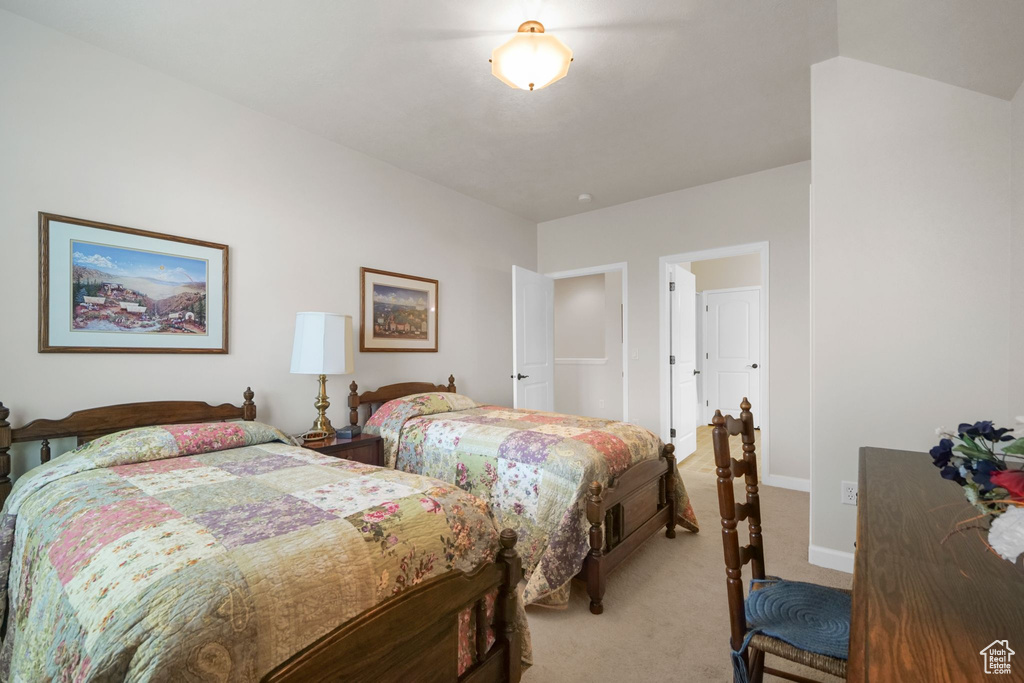 Bedroom with light colored carpet and baseboards