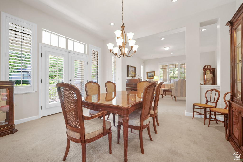 Dining space with light colored carpet, recessed lighting, a chandelier, and french doors