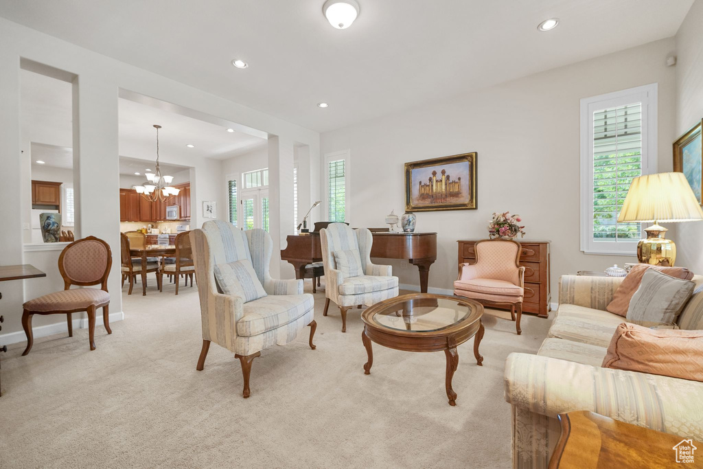 Living room featuring recessed lighting, light colored carpet, plenty of natural light, and a chandelier