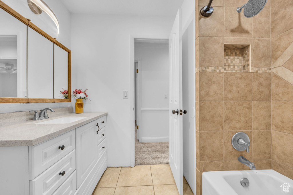 Bathroom with vanity, tile patterned flooring, washtub / shower combination, and ceiling fan