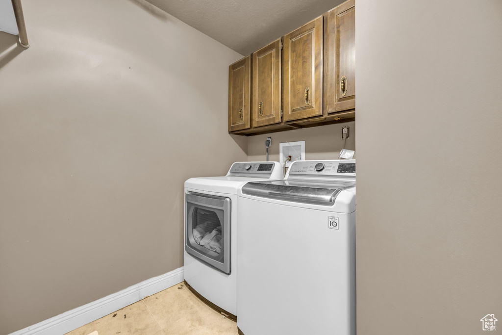 Laundry room with washing machine and clothes dryer and cabinet space