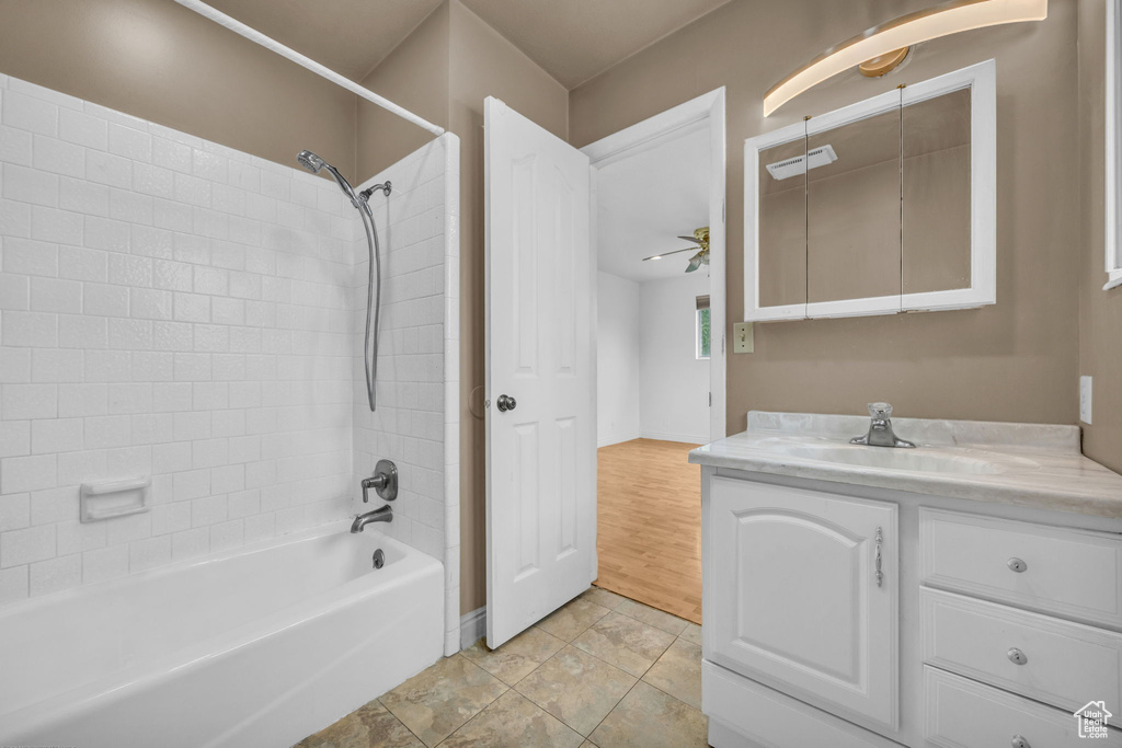 Full bathroom with vanity,  shower combination, ceiling fan, and tile patterned floors