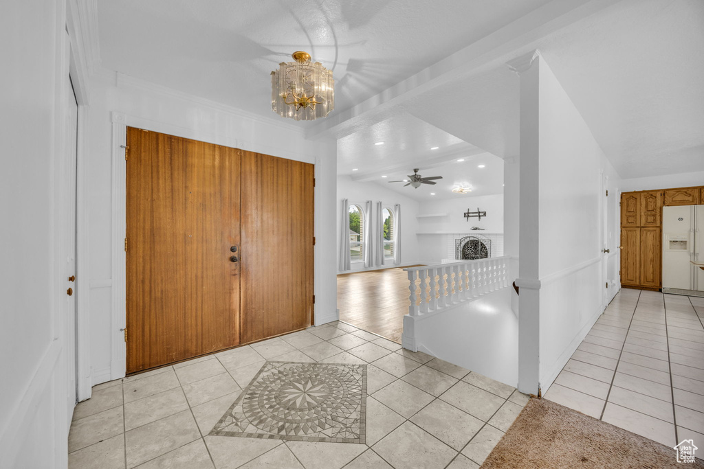 Entryway with light tile patterned floors, a brick fireplace, a chandelier, recessed lighting, and ceiling fan