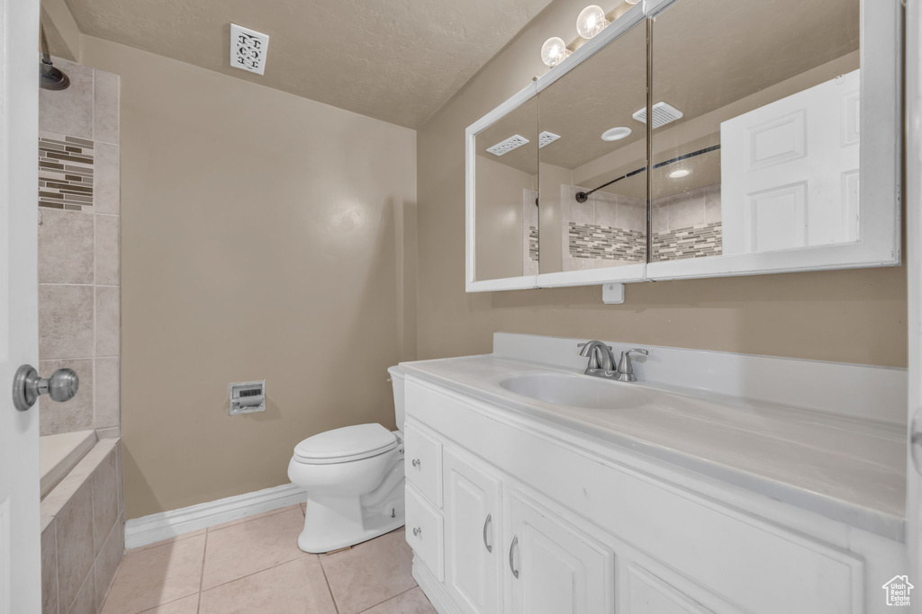 Bathroom featuring tile patterned floors, a tile shower, vanity, and a tub
