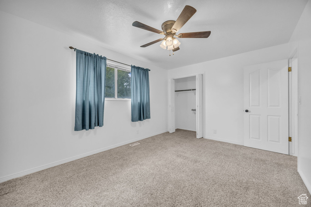 Unfurnished bedroom featuring carpet flooring, a closet, and ceiling fan