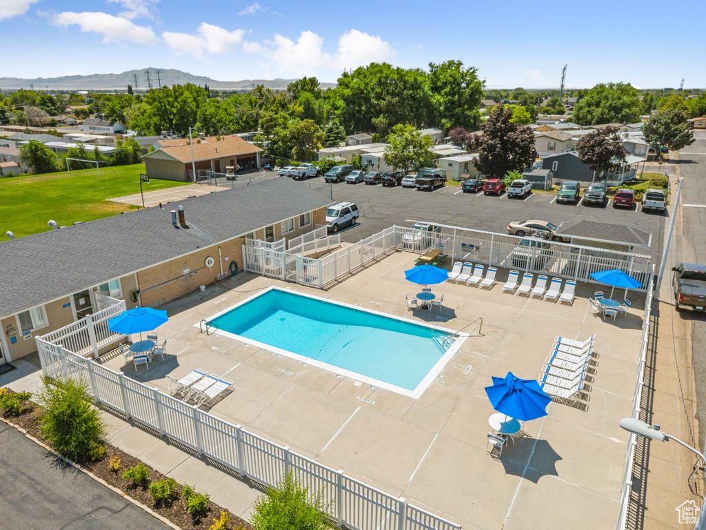 Community pool featuring a mountain view and a patio area