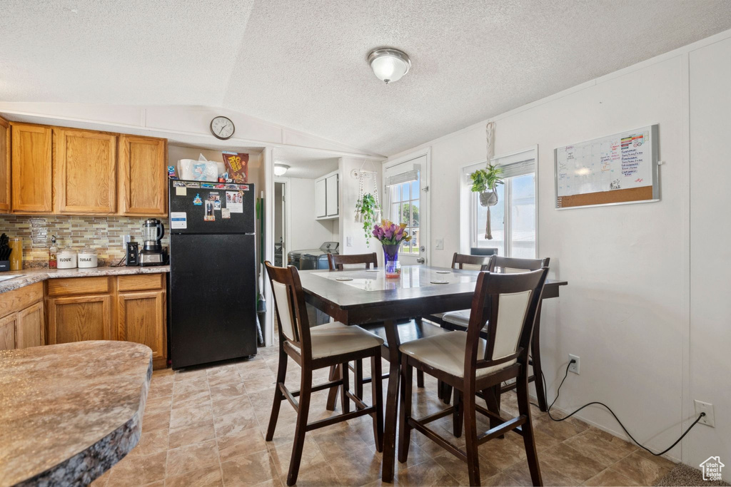 Dining space featuring vaulted ceiling and a textured ceiling