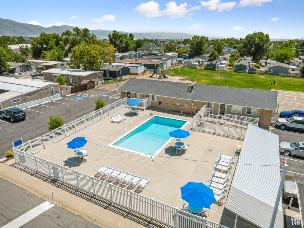 Community pool with a patio area, a mountain view, and a residential view