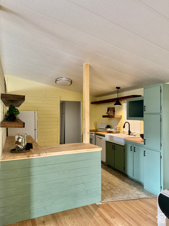 Kitchen with open shelves, white appliances, green cabinetry, light wood-type flooring, and a textured ceiling