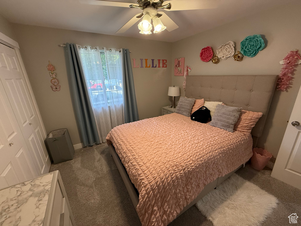 Carpeted bedroom with a ceiling fan