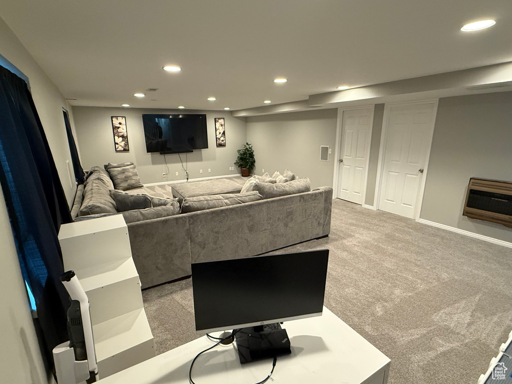 Carpeted living area featuring recessed lighting and heating unit