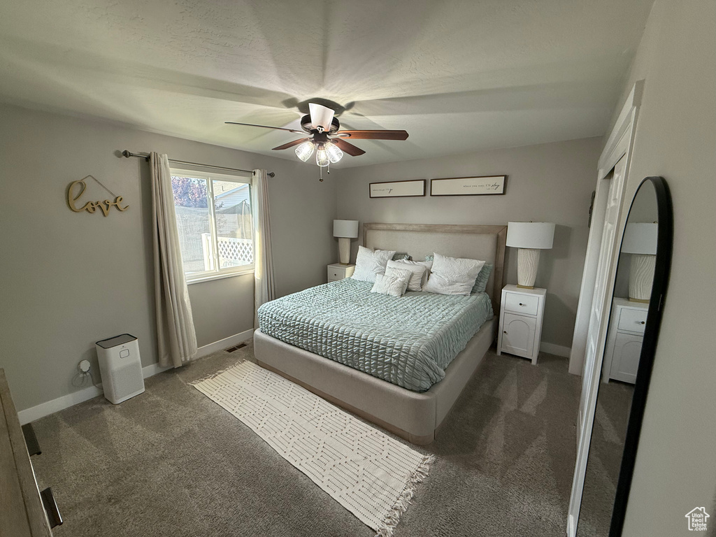 Bedroom featuring dark colored carpet and a ceiling fan