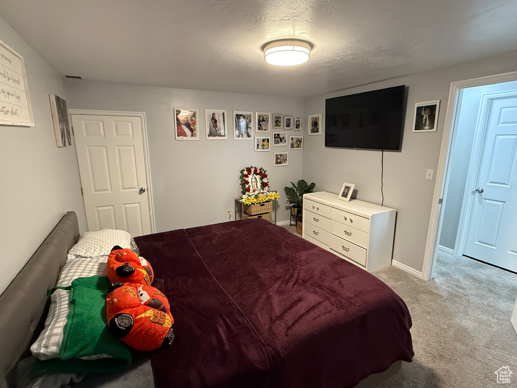 Bedroom featuring light carpet and baseboards