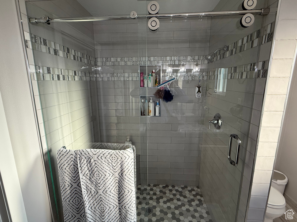 Full bathroom featuring toilet and a shower stall