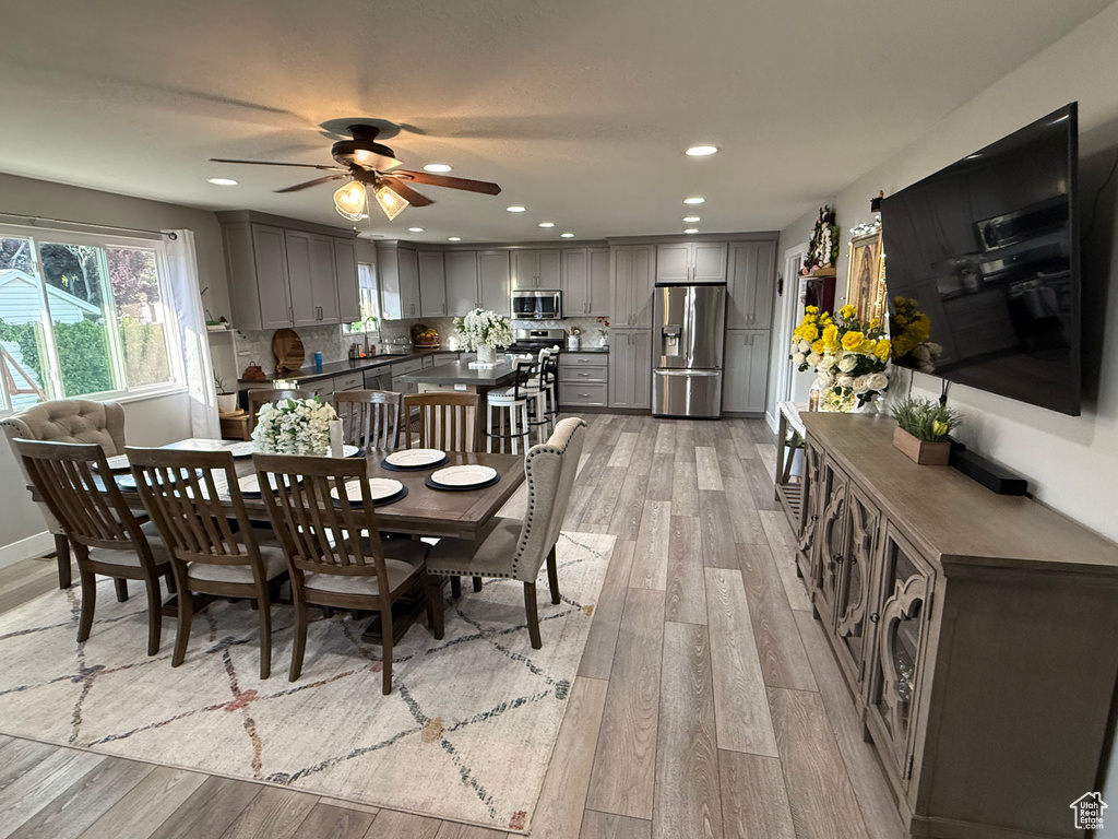 Dining room featuring light wood finished floors, ceiling fan, and recessed lighting