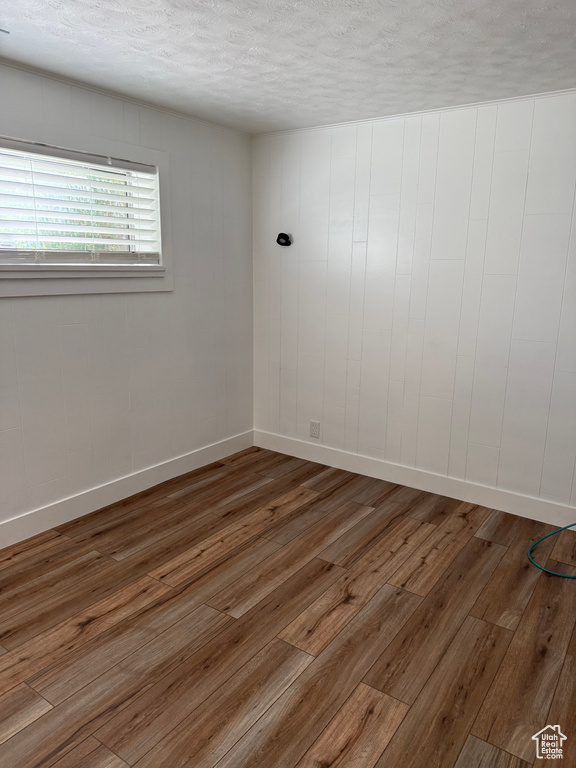 Spare room featuring hardwood / wood-style flooring and a textured ceiling