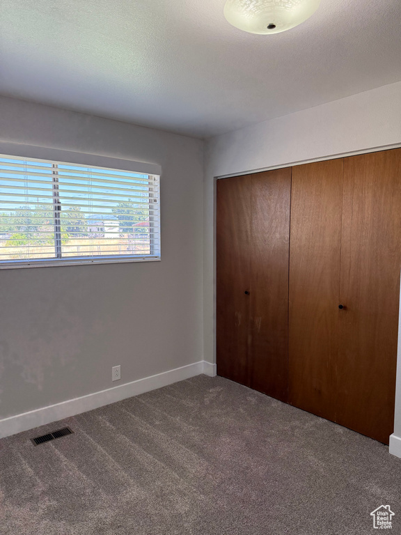 Unfurnished bedroom with carpet and a closet
