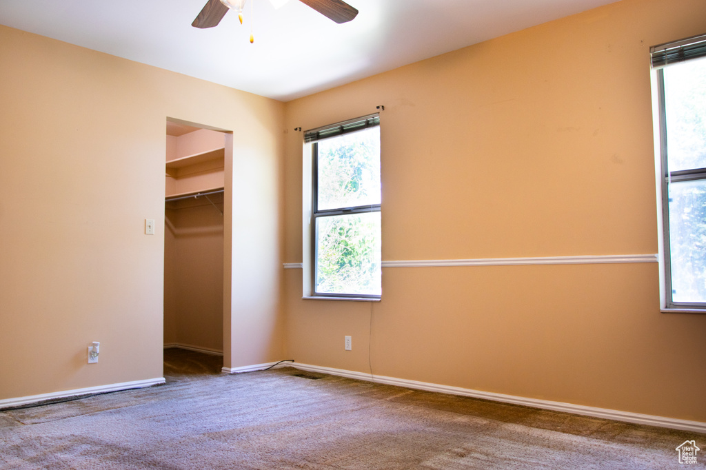Unfurnished bedroom with multiple windows, carpet floors, and ceiling fan