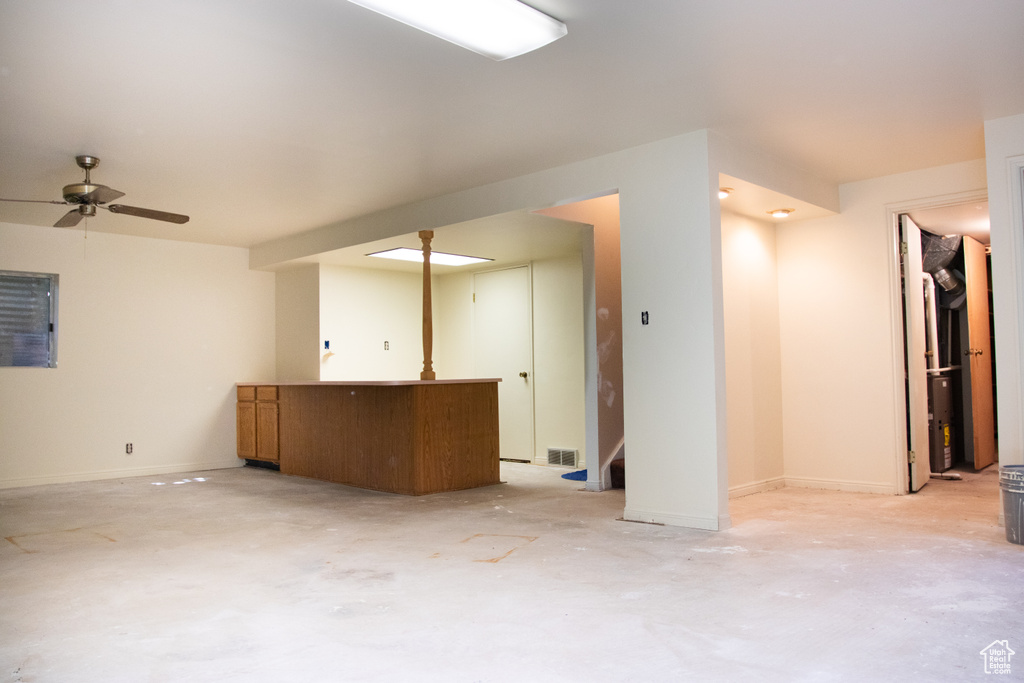 Unfurnished living room featuring concrete flooring and ceiling fan