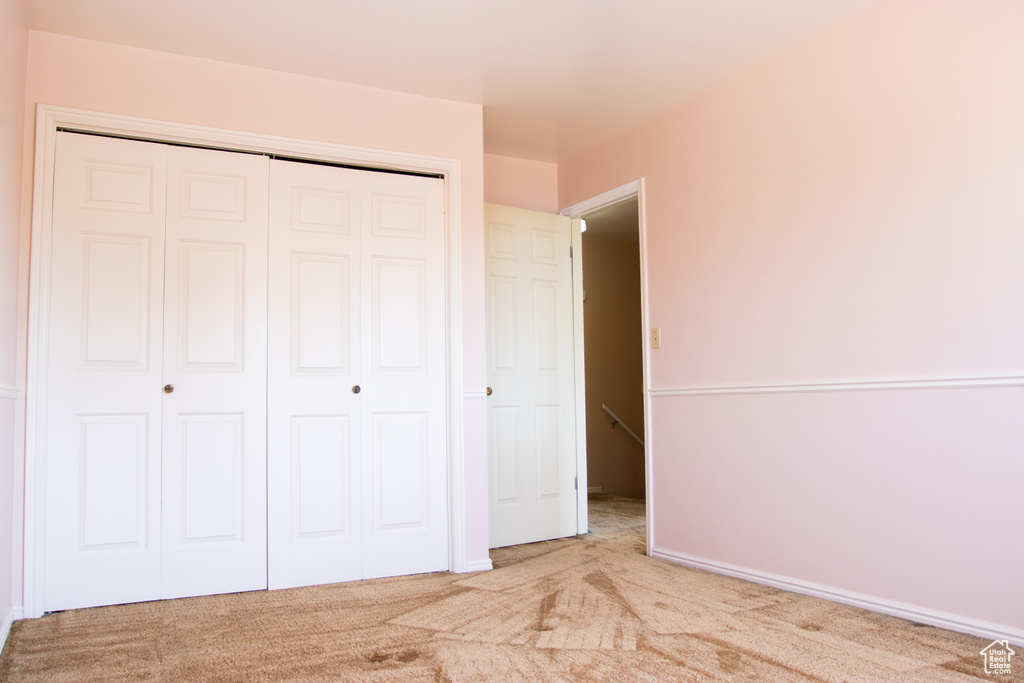 Unfurnished bedroom with a closet and carpet flooring