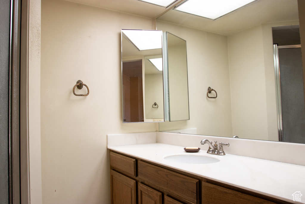 Bathroom with vanity and a shower with shower door