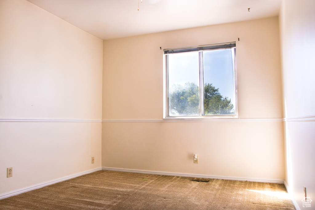 Carpeted empty room featuring baseboards