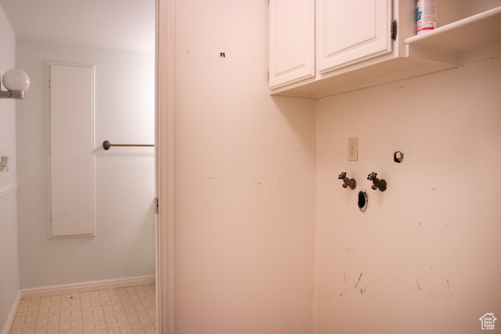 Washroom with cabinet space and tile patterned floors
