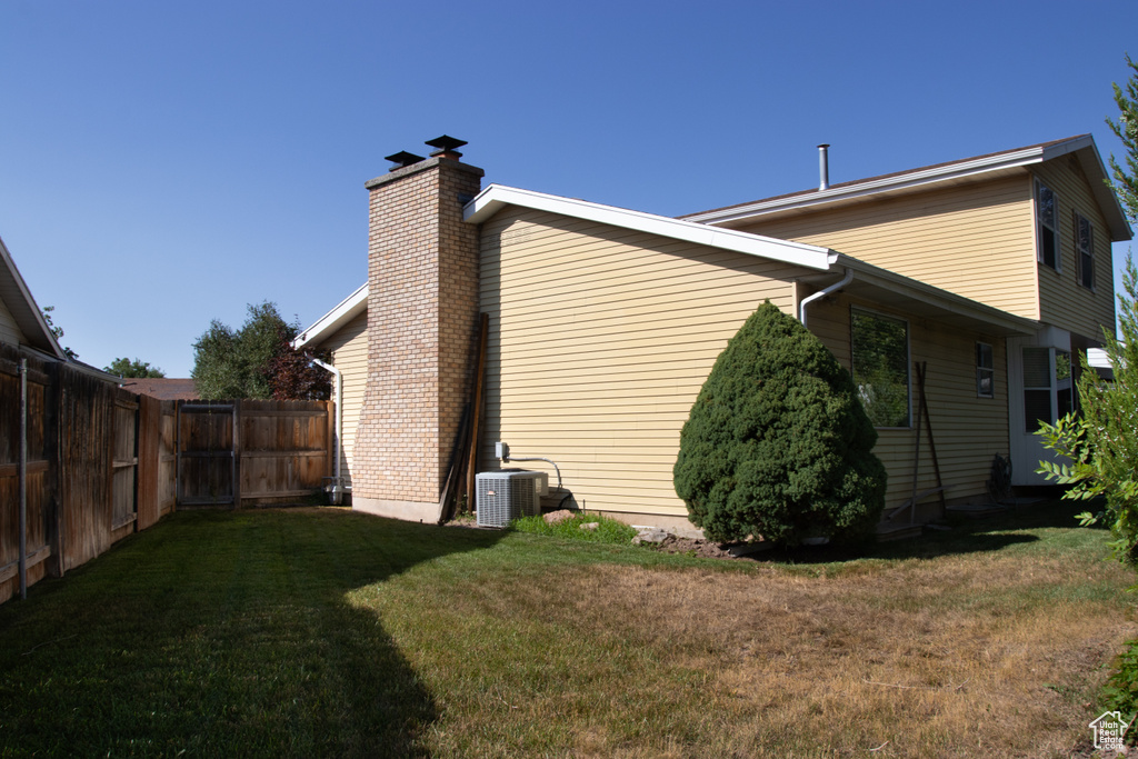 View of home's exterior with a chimney and a central AC unit