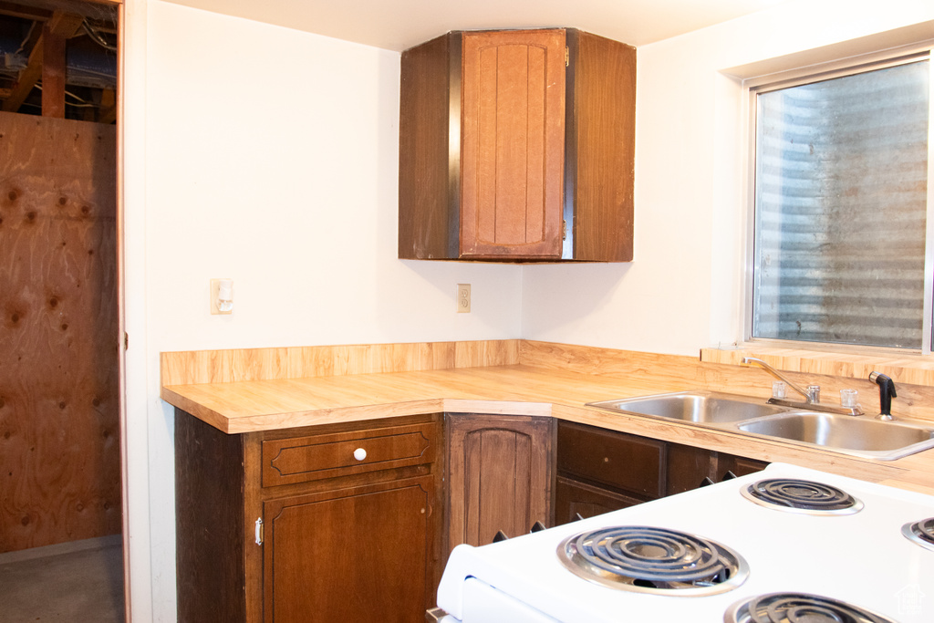 Kitchen with white electric stove and brown cabinets