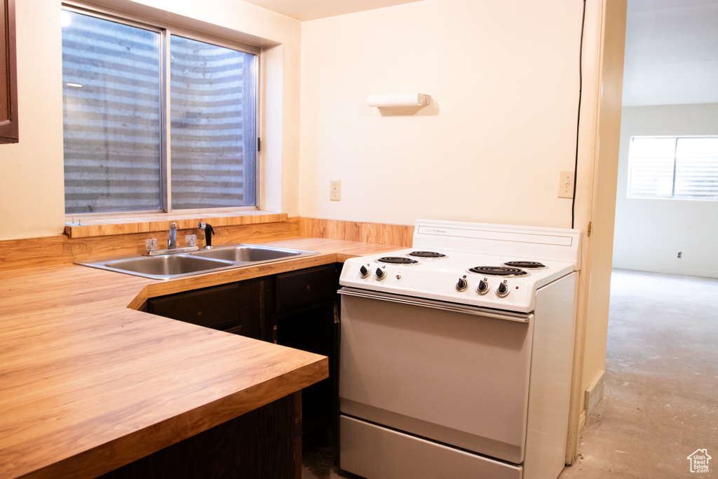 Kitchen featuring white electric range oven and wooden counters