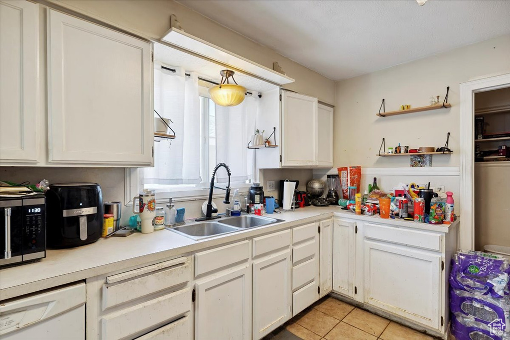 Kitchen featuring dishwasher, white cabinetry, light tile patterned floors, light countertops, and open shelves