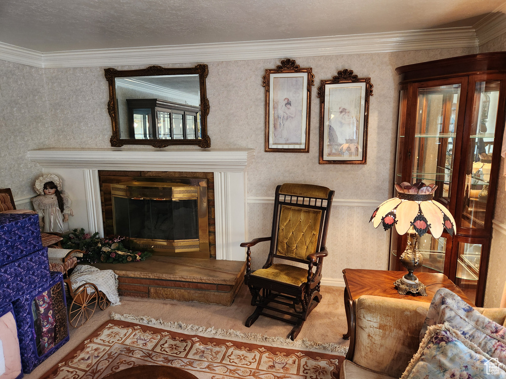 Living area with a glass covered fireplace, wallpapered walls, and crown molding